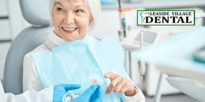 Dental implants happy patient looking at them at Leaside Village Dental